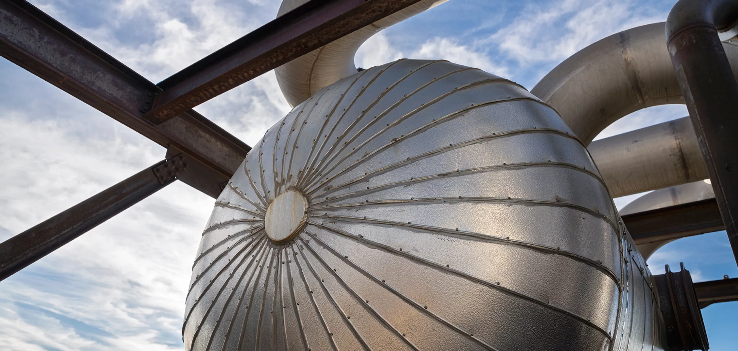 Steel equipment at an operating facility, with blue sky above.